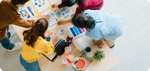 Creative agency team collaborating around screens with analytics dashboards